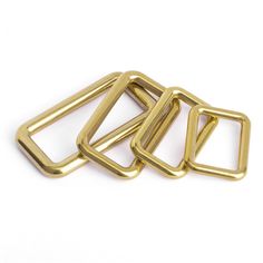 three gold metal buckles on a white background