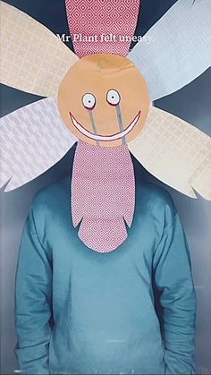 a man wearing a paper mask with wings on it's head and smiling face