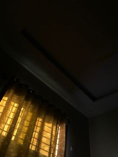 the sun is shining through the curtains in the dark room with light coming from it