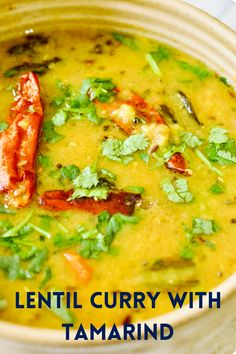 lentil curry with tamarind in a bowl on a white tablecloth and text overlay that reads lentil curry with tamarinoi