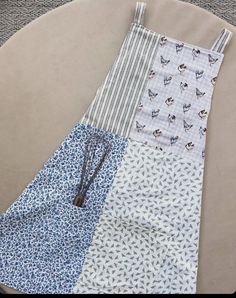 Just as quality cooking tools make the food taste better, a pretty apron makes the cook/baker enjoy the experience while keeping those clothes free of flour and grease.  - Completely hand sewn with love - Featuring two front pockets, perfect for keeping your phone or spatula within reach - Made up of four coordinating fabrics: chickens, neutral stripe, blue floral, and bumble bees  - Adorable cross back straps can tie in the back or front Each apron is made by a stay at home mama to three littles, so please allow 1 to 2 weeks for your order to ship! How To Make An Apron, Apron Rack, Apron Aesthetic, Pottery Apron, Patchwork Apron, Homemade Aprons, Pretty Apron, Diy Apron, Cute Apron