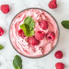 raspberry mousse in a bowl with mint leaves and fresh raspberries on the side