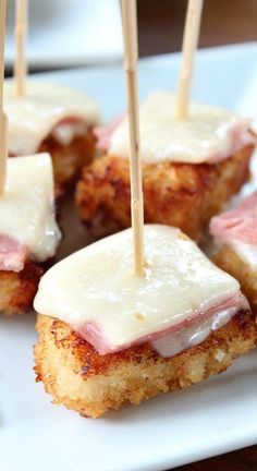 small appetizers with toothpicks are arranged on a plate