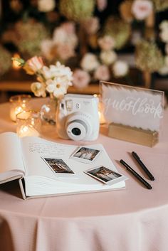 an open book sitting on top of a table next to a camera and other items