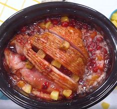 a slow cooker filled with meat and fruit