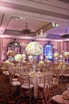 the tables are set with white and pink flowers