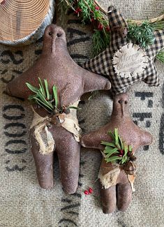 three clay ornaments are on the ground next to some pine cones