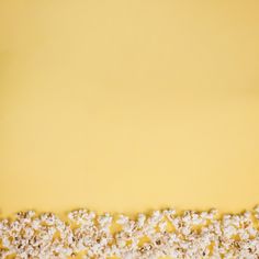 a cake with white and yellow frosting on it's edges is sitting in front of a yellow background