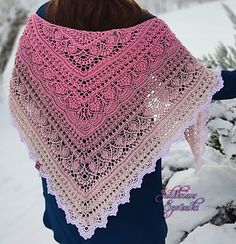 a woman standing in the snow wearing a pink shawl