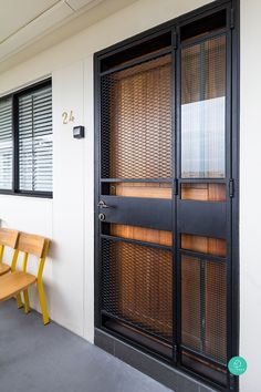 an empty room with wooden benches and glass doors on the outside, along with black shutters