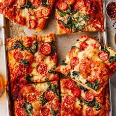 several square slices of pizza on a pan