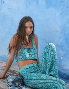 a woman sitting on the ground wearing a blue outfit