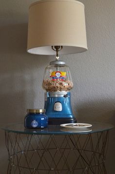 a lamp on top of a table next to a bowl of cereal and a jar