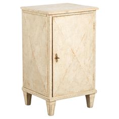 a white cabinet with two legs and a door on one side, it is made out of marble