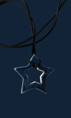 a star shaped pendant hanging from a black cord