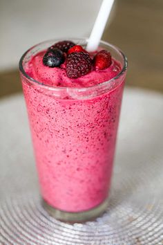 a smoothie with raspberries and strawberries in it on a glass plate