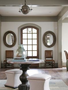 a living room filled with furniture and a large mirror over the top of it's table