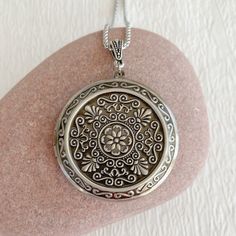 "Timeless and classic, this lovely, embossed antiqued silver locket will become a special addition to your jewelry collection. The locket is extra large at 46mm in diameter and opens for a secret place to keep pictures, messages, or whatever you like. The inside of this locket is deep and can hold two photos. The inside space is approximately 30mm in diameter. The locket is made from lightweight silver plated brass. It has been deeply embossed with an intricate pattern. It hangs on an antique si Antique Silver Locket Necklace For Vintage Collection, Antique Silver Locket Necklace Nickel Free, Vintage Silver Locket Necklace With Round Pendant, Silver Vintage Locket Necklace With Round Pendant, Vintage Silver Medallion Locket Necklace, Silver Vintage Medallion Locket Necklace, Antique Silver Sterling Silver Vintage Locket Necklace, Vintage Locket Necklace For Personalized Gift, Ornate Antique Silver Pendant Locket Necklace