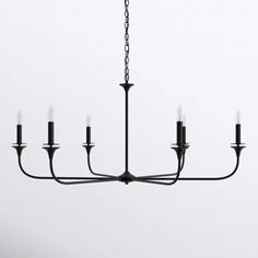 a black chandelier with six candles hanging from it's center, in front of a white background