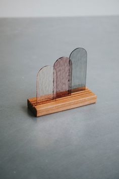 three pieces of glass sitting on top of a wooden stand