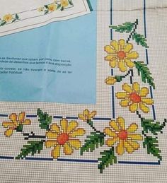 a cross stitch pattern with yellow flowers and green leaves on the bottom half of it