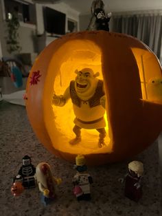 the inside of a pumpkin with toy figures surrounding it