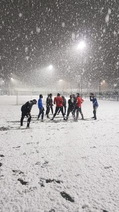 a group of people walking across a snow covered field