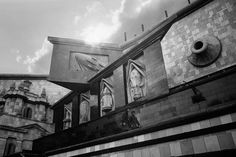 a black and white photo of a building with a clock on it's side