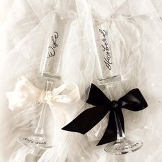 two wine glasses with black bows are sitting next to each other on a white background