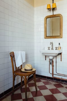 a chair and sink in a bathroom with checkered flooring on the floor,