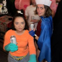 two women dressed up in costumes holding cans