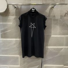 Elevate your casual fashion game with the Rick Owens Men's Casual Fashion T-Shirt. This streetwear-inspired tee boasts the distinctive Rick Owens Star design, setting you apart in style. Whether you're looking for a black Rick Owens designer t-shirt for yourself or as a thoughtful gift for him, this cotton tee effortlessly combines comfort and high street fashion. Key Features: Applicable Season: Designed for spring and summer, this t-shirt offers both style and breathability in warmer weather, making it perfect for any season. Applicable Scene: Ideal for trips and adventures, this t-shirt ensures you stay fashionable and comfortable wherever you go. Hooded: This t-shirt is not hooded, offering a classic look that's versatile for various occasions. Pattern Type: With a solid pattern, this Black Short Sleeve Tops With Star Print, Rick Owens Pentagram, Rick Owens Hoodie, Abstract Rick Owens, Men's Casual Fashion, Rick Owens Fashion, Street Mode, Rick Owens Shirt, Rick Owens Spring 2024 Menswear