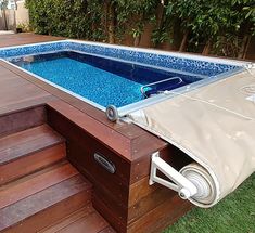 an above ground swimming pool with steps leading up to it and a cover over the bottom