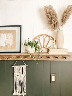 a shelf with some plants and pictures on it