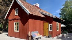 a small red house with a bench in front of it