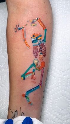 a colorful skeleton tattoo on the arm