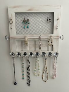 a wall mounted jewelry rack with earrings hanging on it