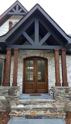 the front entrance to a home with stone and wood