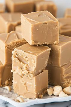 peanut butter fudge bars stacked on top of each other with cashews around them