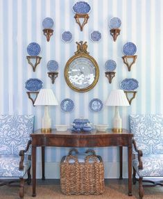 a room with blue and white striped wallpaper, two lamps on either side of the table