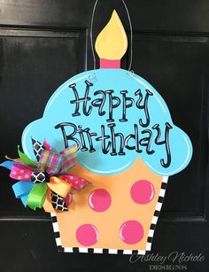 a happy birthday cupcake door hanger with a candle on it's top