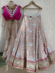 This gorgeous nude georgette umbrella lehenga with big sequin and thread work butti and gota work border is paired with a fuchsia raw silk blouse with mirror and thread work hand embroidery. The outfit is completed with a nude ruffled stole. Chickenkari Lehenga Blouse Designs, Umbrella Lehnga Designs, Chickenkari Lehenga, Nude Lehenga, Umbrella Lehenga, Ruffle Dupatta, Wedding Lehenga Choli, Raw Silk Blouse, Indian Outfits Lehenga