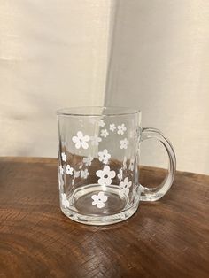 a clear glass mug with white flowers on it