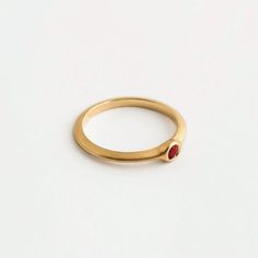 Our round ruby engagement gold ring is a dainty ring with a small ruby set within it. The ring is part of the 'Strings' ring family, a series of rings with a triangular profile and a small stone set in a variety of ways. They stack together gently, with small airy spaces between them, and can be suitable as engagement rings. The ring is made using traditional jewelry techniques to create a piece of jewelry that is classic and unique. It is elegant and comfortable to wear and will live with you h Ruby Ring With Round Band For Promise, Promise Ruby Ring With Birthstone, Yellow Gold Ruby Ring With Bezel Setting For Promise, Yellow Gold Ruby Promise Ring With Birthstone, Ruby Promise Ring Birthstone, Stackable Ruby Birthstone Rings With Round Band, Stackable Ruby Birthstone Rings, Ruby Solitaire Birthstone Ring For Promise, Lab-created Ruby Promise Ring With Round Band