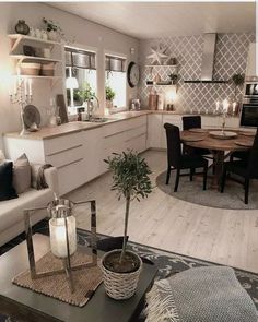 a living room and kitchen area in a house with white walls, wood floors and flooring