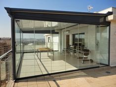 an empty patio with glass walls and sliding doors