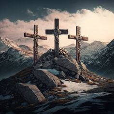 three crosses sitting on top of a rocky hill with snow and mountains in the background