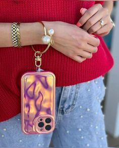 a woman wearing a red sweater holding a cell phone case with an animal design on it