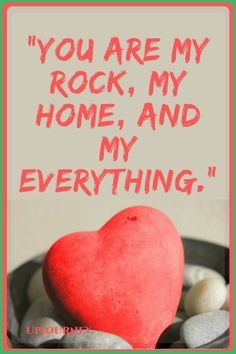 a red heart sitting on top of rocks with the words you are my rock, my home and my everything