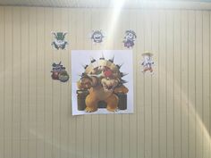 a wall with pictures and stickers on it in the shape of cartoon character characters